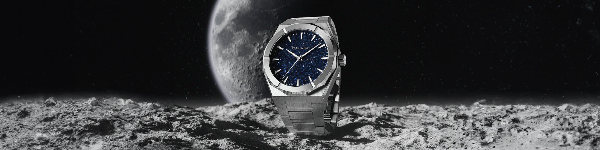 Paul Rich silver watch with blue aventurine dial standing on moon-like terrain with the Earth in the background under a starry sky. Paul Rich silver watch with blue aventurine dial standing on moon-like terrain with the Earth in the background under a starry sky.