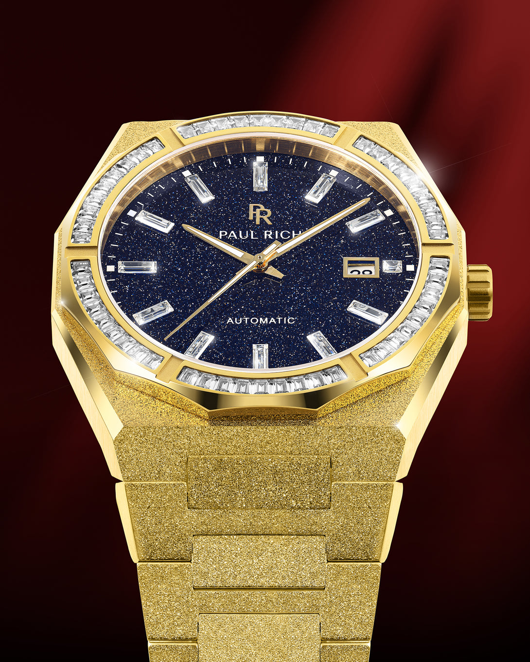 Gold frosted watch with blue aventurine dial, moissanite bezel, and date window at 3 o’clock shown under red studio lighting. Gold frosted watch with blue aventurine dial, moissanite bezel, and date window at 3 o’clock shown under red studio lighting.