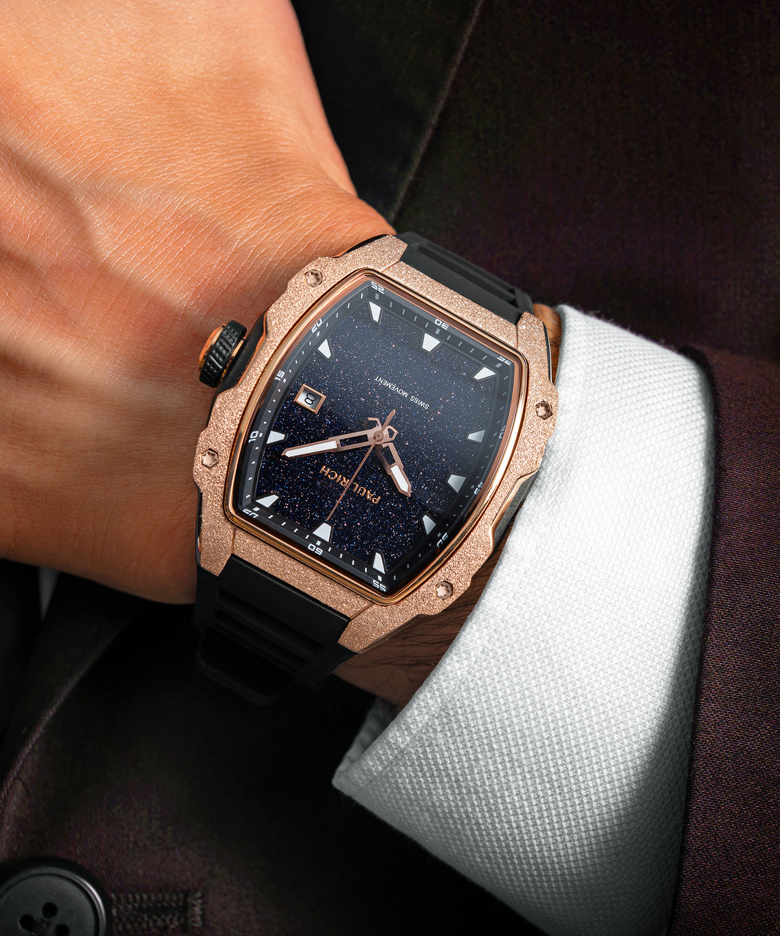 Paul Rich watch with blue aventurine dial and rose gold frosted bezel worn on wrist, paired with white cuff and dark suit jacket. Paul Rich watch with blue aventurine dial and rose gold frosted bezel worn on wrist, paired with white cuff and dark suit jacket.