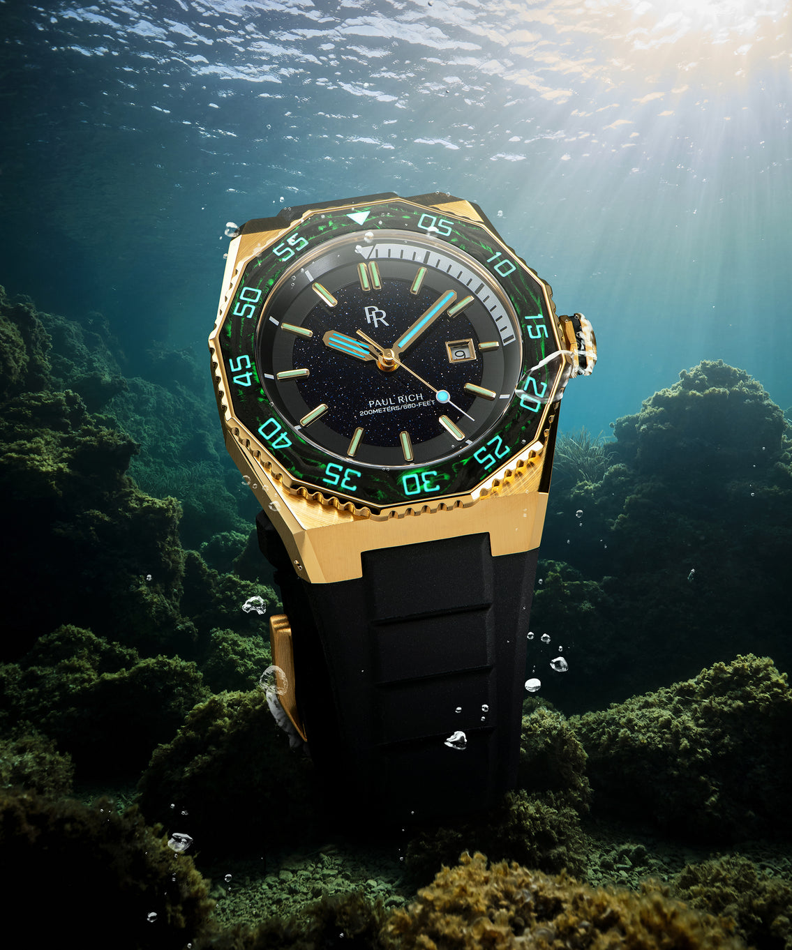 Paul Rich dive watch with gold case and aventurine dial glowing green underwater, white dive timer, sunbeams shining from above. Paul Rich dive watch with gold case and aventurine dial glowing green underwater, white dive timer, sunbeams shining from above.