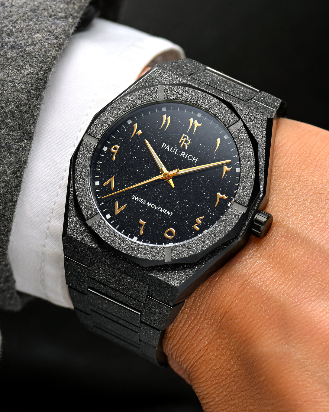 Close-up of Paul Rich frosted black watch with gold Arabic numerals and black aventurine dial, worn. Close-up of Paul Rich frosted black watch with gold Arabic numerals and black aventurine dial, worn.
