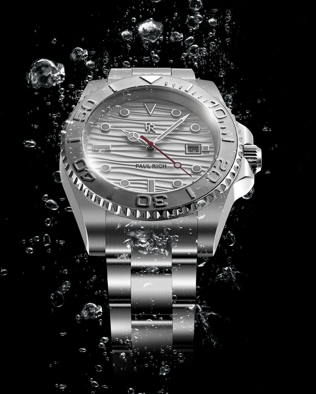 Stainless steel watch with a silver wave-textured dial shown against splashing water on a black background, highlighting the bezel, bracelet, and red seconds hand. Stainless steel watch with a silver wave-textured dial shown against splashing water on a black background, highlighting the bezel, bracelet, and red seconds hand.