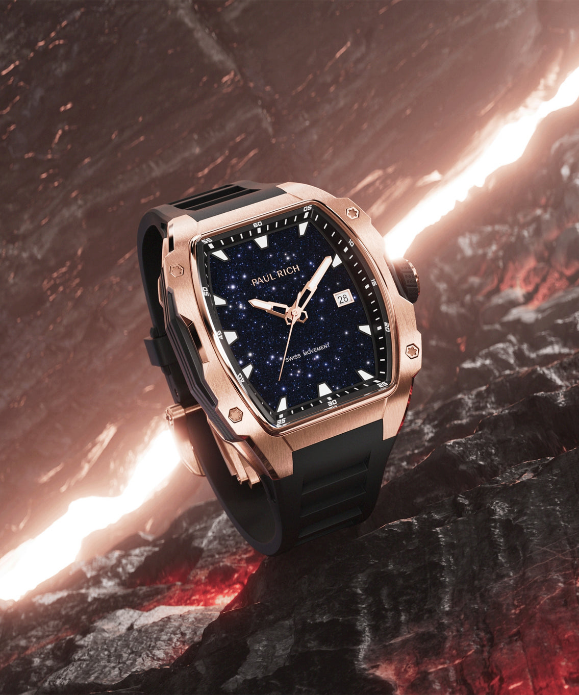 Paul Rich rose gold-tonneau watch with blue aventurine dial, rose gold hands, and black strap displayed on dark rock with glowing lava fissure. Paul Rich rose gold-tonneau watch with blue aventurine dial, rose gold hands, and black strap displayed on dark rock with glowing lava fissure.