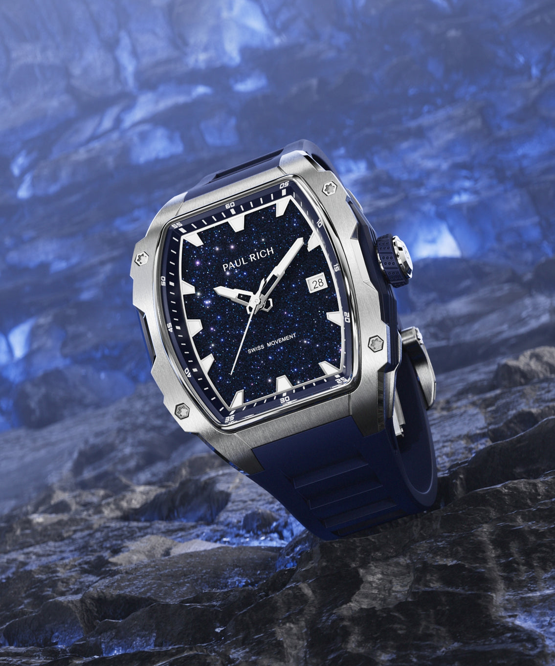 Paul Rich silver-tonneau watch with blue aventurine dial, silver hands, and blue strap displayed on textured dark blue rock surface. Paul Rich silver-tonneau watch with blue aventurine dial, silver hands, and blue strap displayed on textured dark blue rock surface.