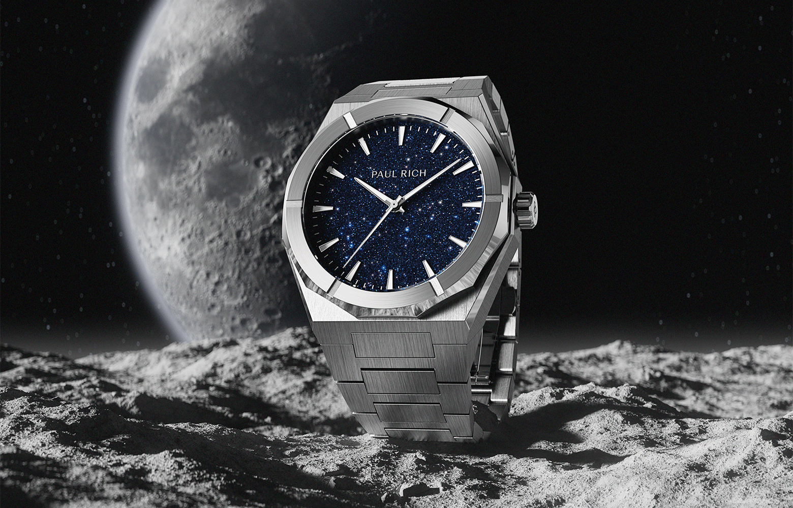 Paul Rich brushed silver watch with blue aventurine dial standing on a lunar surface with the moon and stars in the background. Paul Rich brushed silver watch with blue aventurine dial standing on a lunar surface with the moon and stars in the background.
