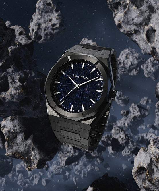 Paul Rich black stainless steel watch with blue aventurine dial, floating among dark asteroids in deep space setting. Paul Rich black stainless steel watch with blue aventurine dial, floating among dark asteroids in deep space setting.