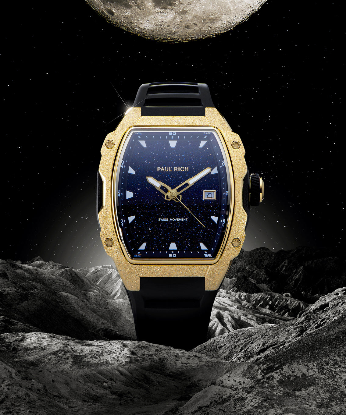 Paul Rich tonneau-shaped watch with blue aventurine dial and gold frosted bezel displayed against moonlit space and rocky lunar terrain. Paul Rich tonneau-shaped watch with blue aventurine dial and gold frosted bezel displayed against moonlit space and rocky lunar terrain.
