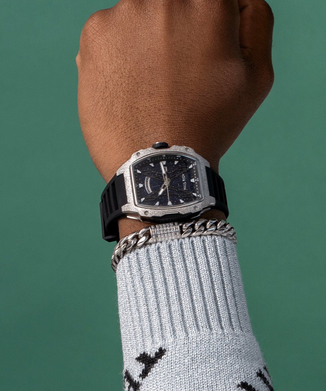 Paul Rich watch with blue aventurine dial and silver frosted bezel worn on wrist, paired with silver bracelet and light blue sweater. Paul Rich watch with blue aventurine dial and silver frosted bezel worn on wrist, paired with silver bracelet and light blue sweater.
