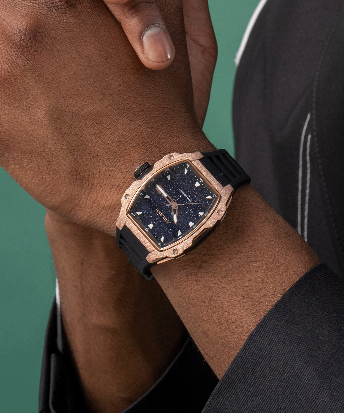 Paul Rich watch with blue aventurine dial and rose gold frosted bezel worn on wrist, paired with black outfit and green backdrop. Paul Rich watch with blue aventurine dial and rose gold frosted bezel worn on wrist, paired with black outfit and green backdrop.