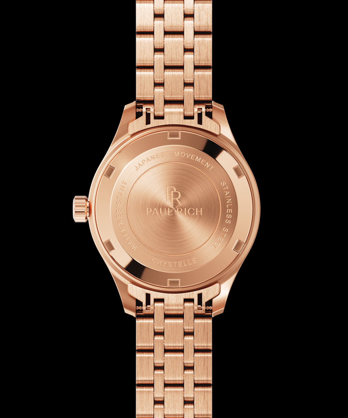 Back view of a rose gold wristwatch showing an engraved caseback with “Paul Rich,” “Japanese Movement,” “Stainless Steel,” and “Crystelle.” Back view of a rose gold wristwatch showing an engraved caseback with “Paul Rich,” “Japanese Movement,” “Stainless Steel,” and “Crystelle.”