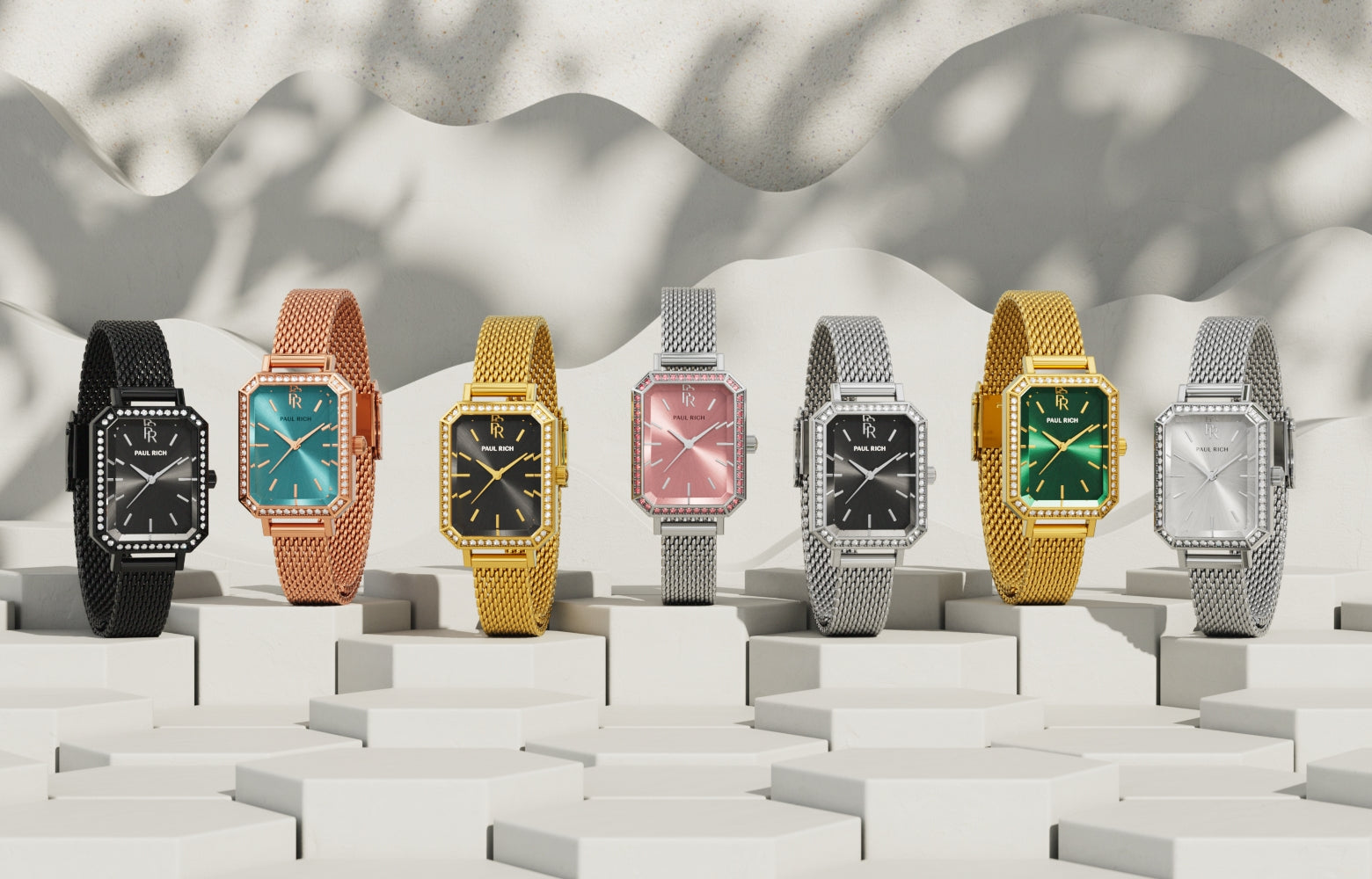 Lineup of Paul Rich rectangular mesh watches in various metals and dial colors, displayed on white pedestals with sculpted shadows. Lineup of Paul Rich rectangular mesh watches in various metals and dial colors, displayed on white pedestals with sculpted shadows.