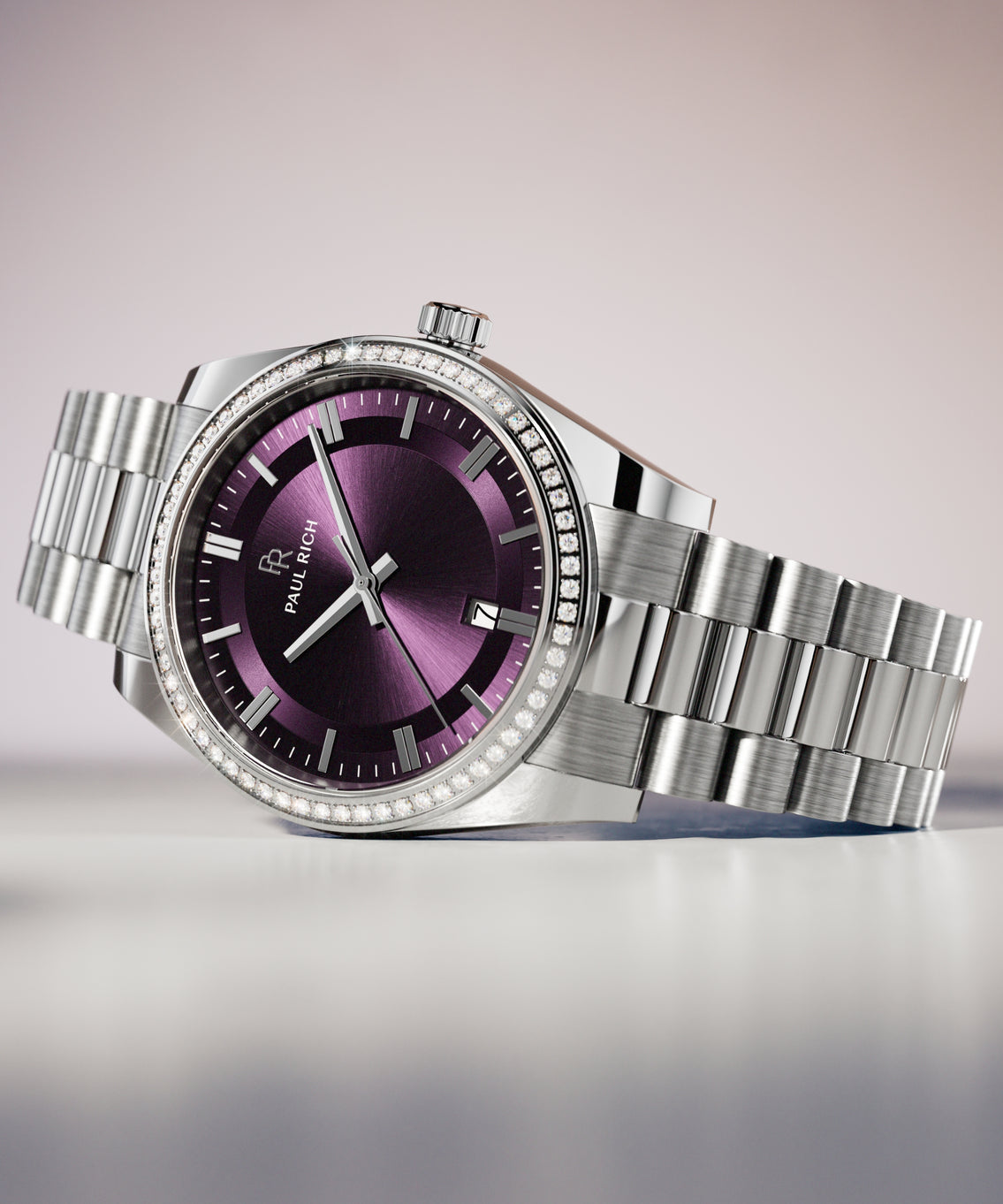 Silver wristwatch with a purple sunburst dial, crystal-set bezel, and metal bracelet displayed on a smooth white surface with soft lighting. Silver wristwatch with a purple sunburst dial, crystal-set bezel, and metal bracelet displayed on a smooth white surface with soft lighting.