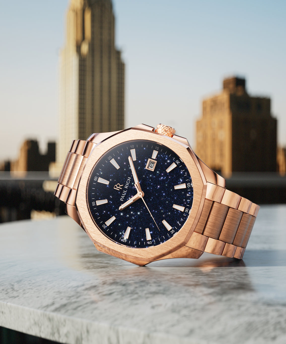Paul Rich watch with brushed rose gold case and blue aventurine dial displayed on rooftop ledge with the Chrysler Building in background. Paul Rich watch with brushed rose gold case and blue aventurine dial displayed on rooftop ledge with the Chrysler Building in background.