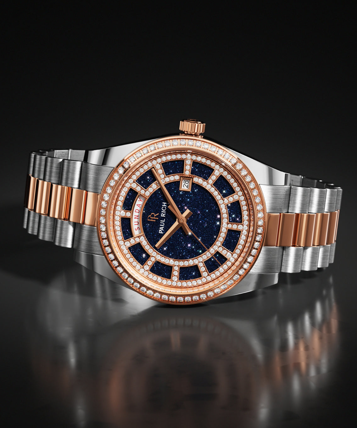 Two-tone silver and rose gold watch with a blue aventurine dial and a pavé stone-set bezel, shown on a steel bracelet against a dark background. Two-tone silver and rose gold watch with a blue aventurine dial and a pavé stone-set bezel, shown on a steel bracelet against a dark background.