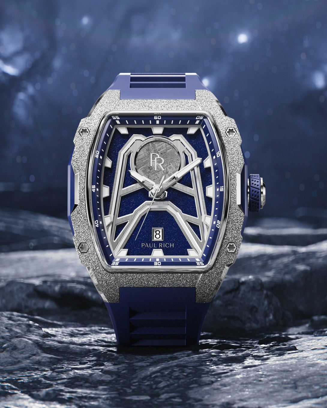 Paul Rich Astro Meteora watch with meteorite inlay, frosted bezel, and navy rubber strap, displayed on a rocky surface under a starry sky. Paul Rich Astro Meteora watch with meteorite inlay, frosted bezel, and navy rubber strap, displayed on a rocky surface under a starry sky.