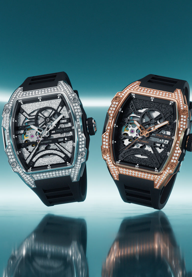 Two skeleton watches with lab-grown diamond bezels in silver and rose gold cases on black silicone straps, set against turquoise neon. Two skeleton watches with lab-grown diamond bezels in silver and rose gold cases on black silicone straps, set against turquoise neon.
