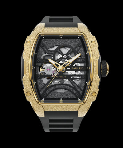 Astro Skeleton Mason Gold Paul Rich watch with frosted gold tonneau case, skeleton dial, gold hands, and black rubber strap, shown on transparent background.