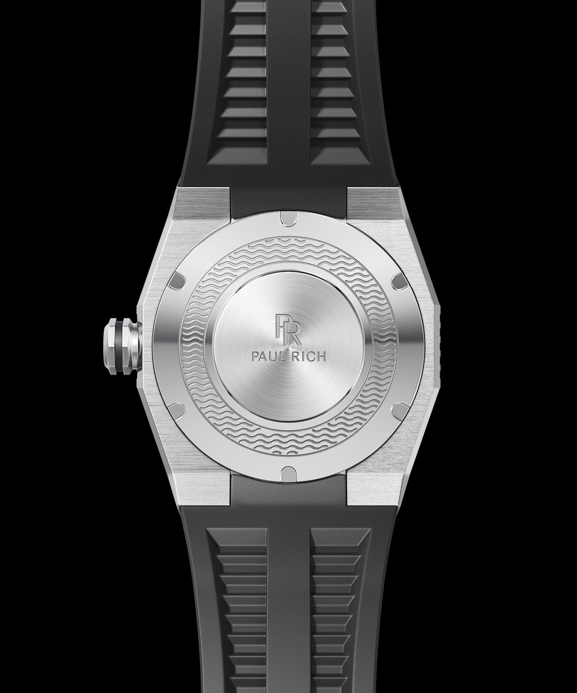 Back view of a Paul Rich dive watch with black rubber strap and brushed steel caseback featuring engraved wave pattern and logo. Back view of a Paul Rich dive watch with black rubber strap and brushed steel caseback featuring engraved wave pattern and logo.