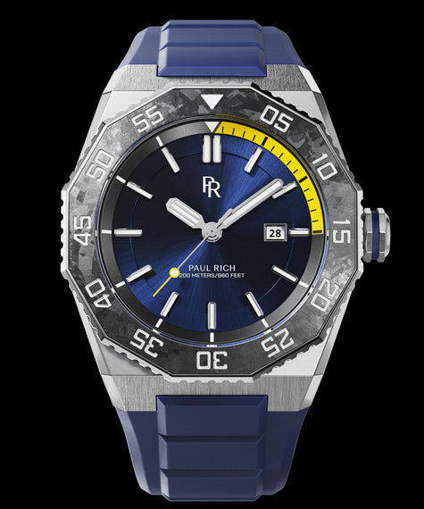 Aquacarbon Pro Horizon Blue - Sunburst Diver-style watch with brushed steel case, carbon bezel, blue dial, yellow depth gauge segment, date window, and blue rubber strap.