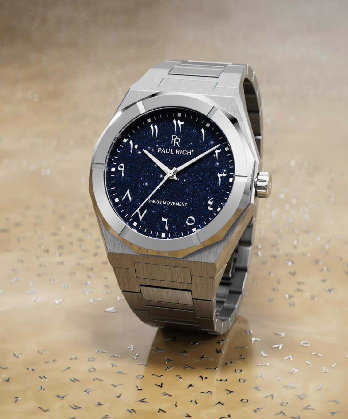Paul Rich watch with brushed silver case and blue aventurine dial with Arabic numerals, displayed on a reflective gold surface with scattered markers. Paul Rich watch with brushed silver case and blue aventurine dial with Arabic numerals, displayed on a reflective gold surface with scattered markers.