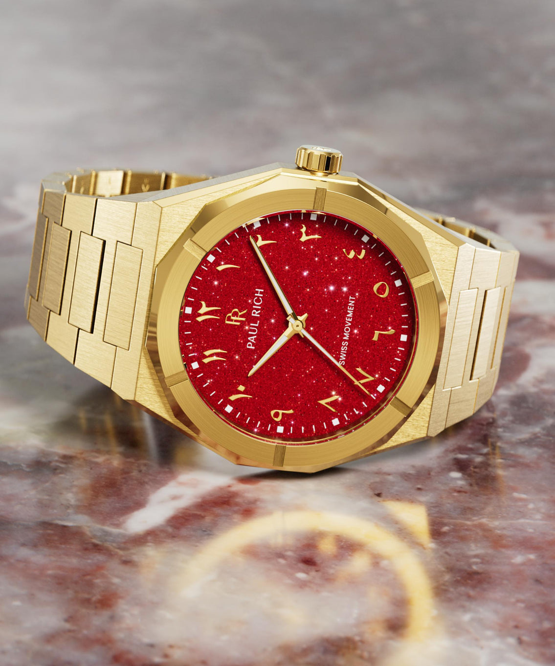 Paul Rich watch with brushed gold case and red aventurine dial featuring Arabic numerals, displayed on a polished red marble surface. Paul Rich watch with brushed gold case and red aventurine dial featuring Arabic numerals, displayed on a polished red marble surface.
