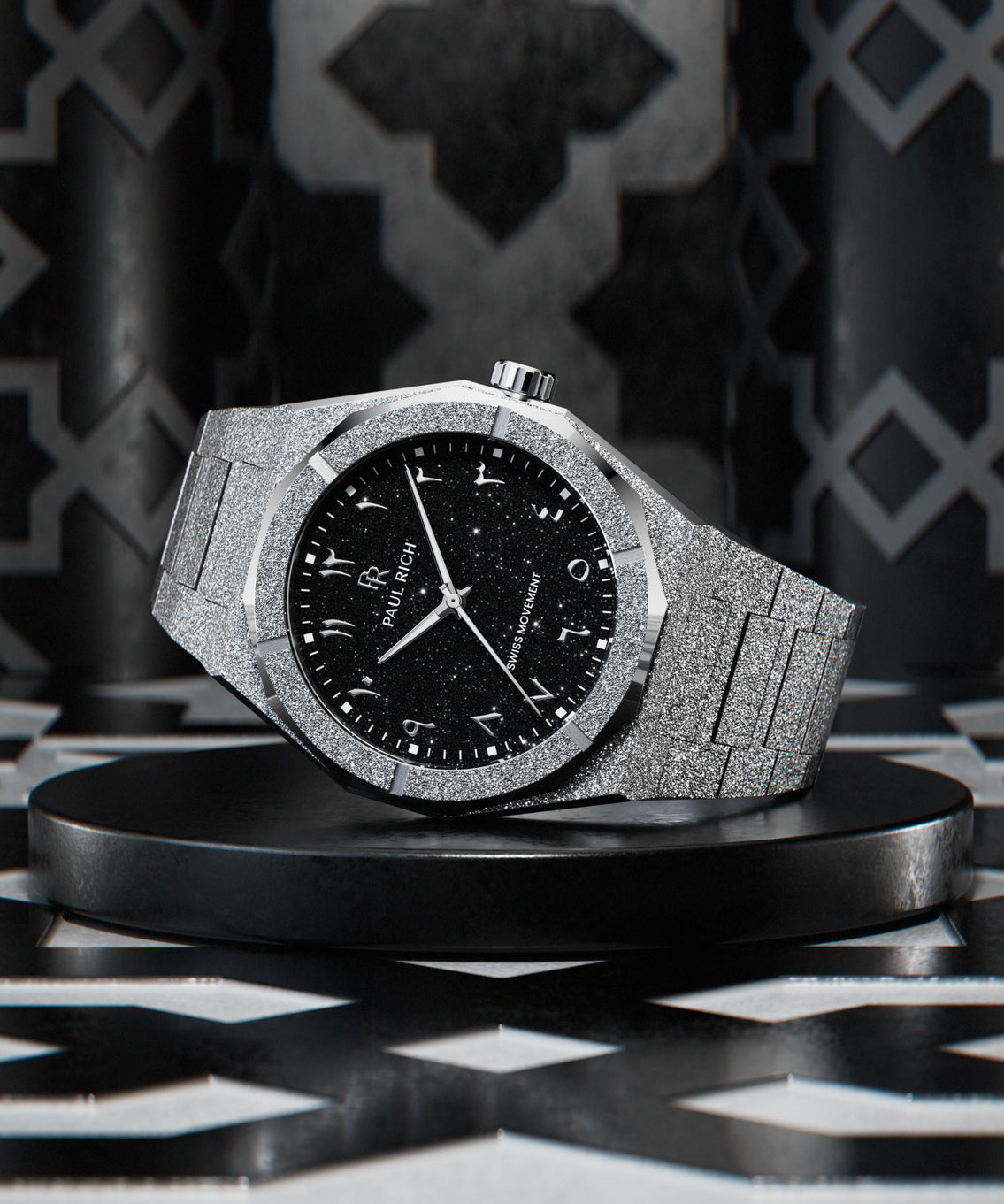 Silver wristwatch with a frosted case and bracelet, black aventurine dial, and silver Arabic numerals displayed on a black platform with geometric patterned background. Silver wristwatch with a frosted case and bracelet, black aventurine dial, and silver Arabic numerals displayed on a black platform with geometric patterned background.