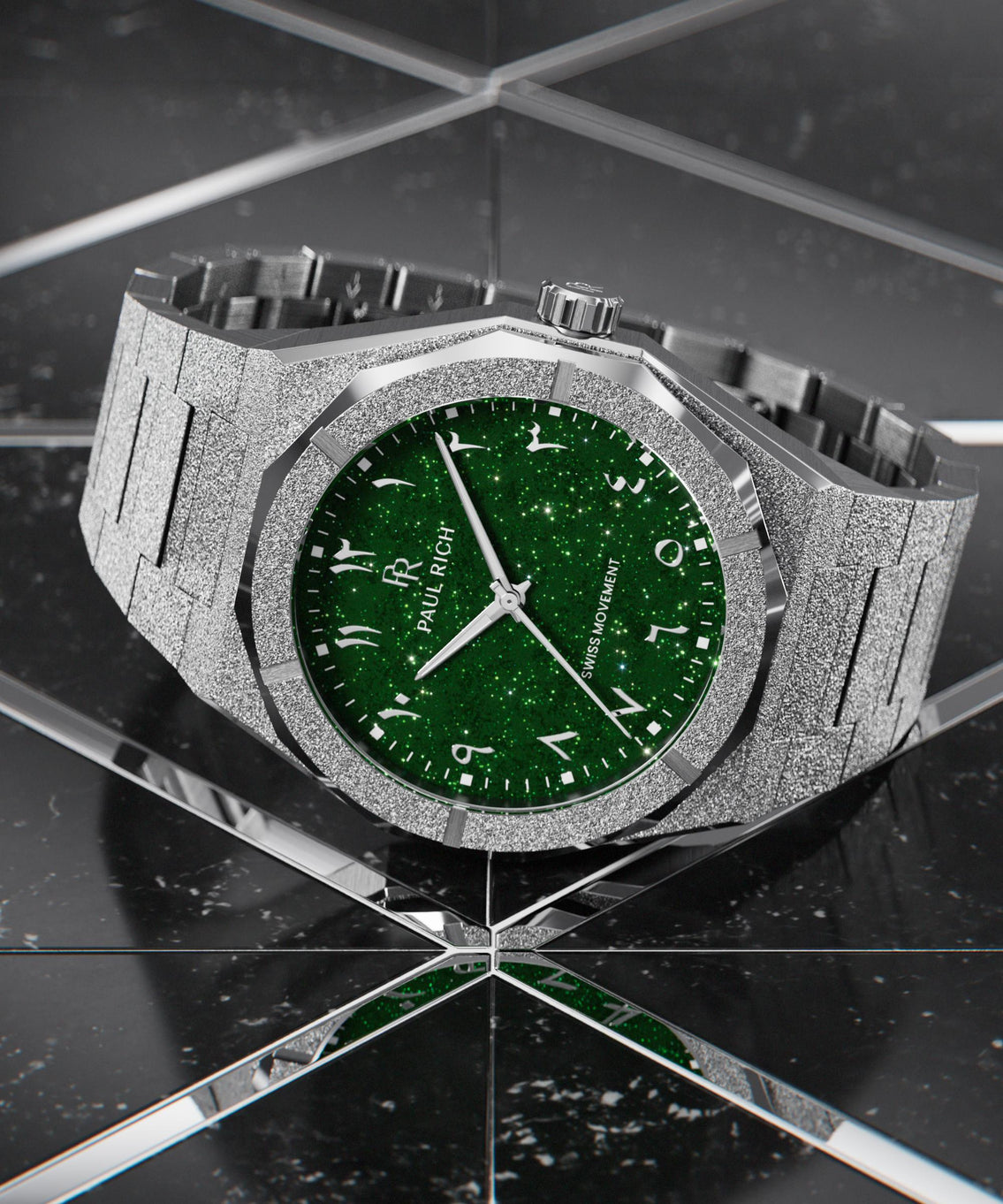 Paul Rich watch with frosted silver case and green aventurine dial with Arabic numerals, displayed on a reflective black tiled surface. Paul Rich watch with frosted silver case and green aventurine dial with Arabic numerals, displayed on a reflective black tiled surface.
