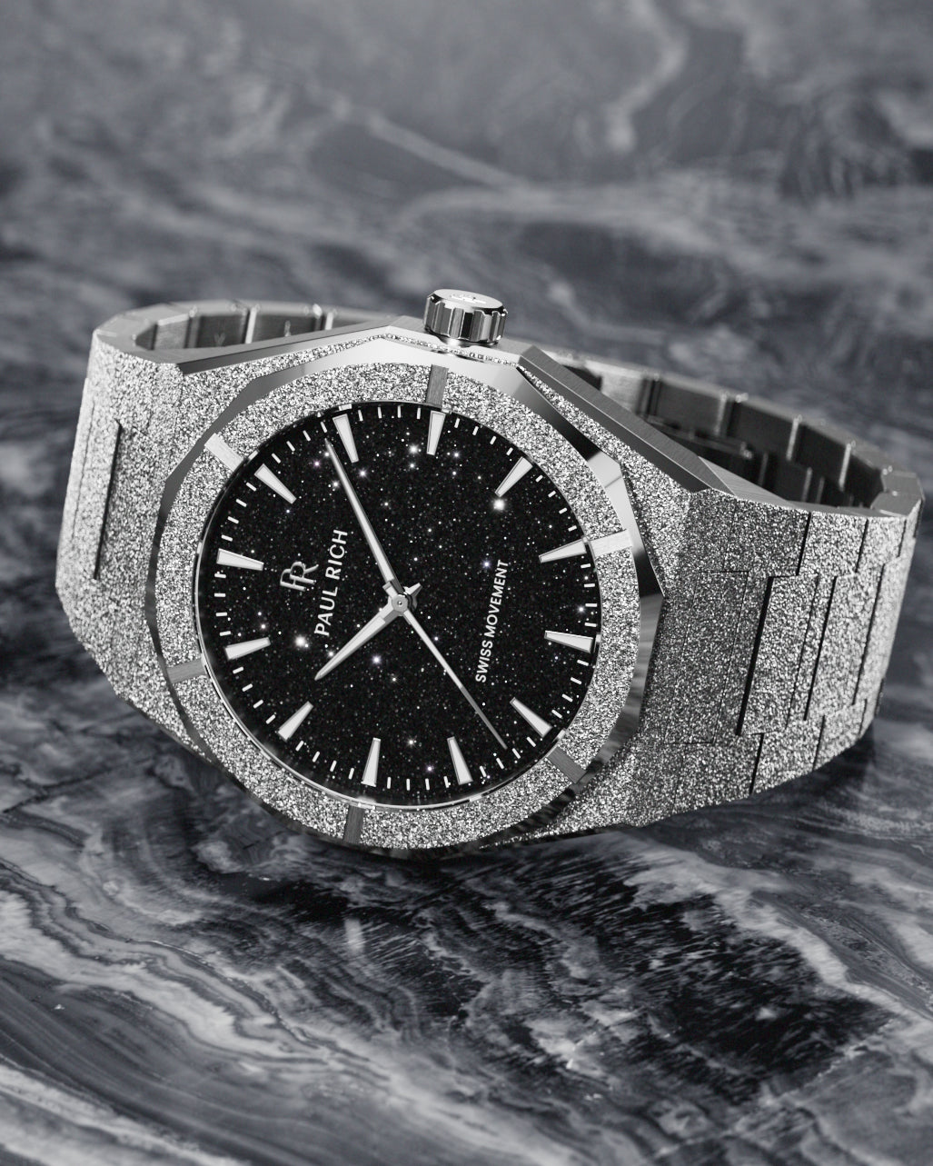 Paul Rich watch with frosted silver case and black aventurine dial, resting on a marbled surface with swirling monochrome texture. Paul Rich watch with frosted silver case and black aventurine dial, resting on a marbled surface with swirling monochrome texture.