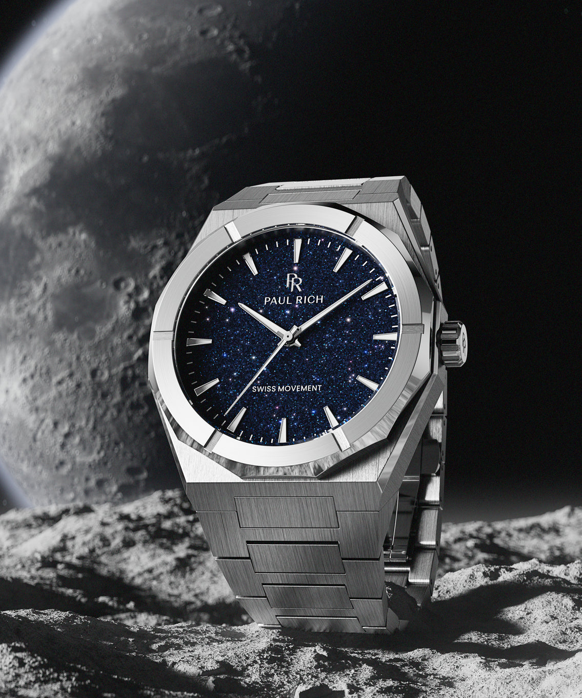 Silver Paul Rich watch with blue aventurine dial placed on rocky surface, with moon and space background evoking a lunar setting. Silver Paul Rich watch with blue aventurine dial placed on rocky surface, with moon and space background evoking a lunar setting.