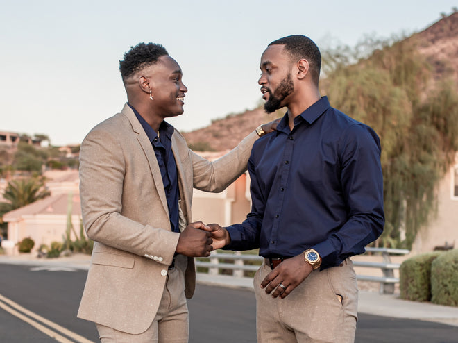 Two stylish men greeting each other on a suburban street; one wears a navy shirt and gold Paul Rich watch with blue dial. Two stylish men greeting each other on a suburban street; one wears a navy shirt and gold Paul Rich watch with blue dial.
