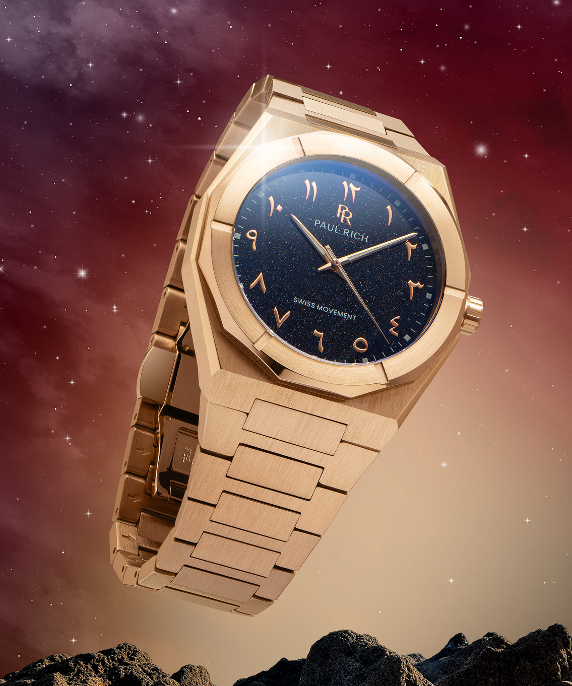 Paul Rich watch with brushed rose gold case and blue aventurine dial with Arabic numerals, displayed in a cosmic setting with stars and rocks. Paul Rich watch with brushed rose gold case and blue aventurine dial with Arabic numerals, displayed in a cosmic setting with stars and rocks.
