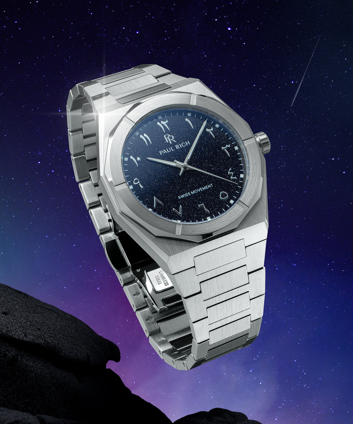 Paul Rich watch with brushed silver case and blue aventurine dial with Arabic numerals, shown against a starry night sky with shooting star. Paul Rich watch with brushed silver case and blue aventurine dial with Arabic numerals, shown against a starry night sky with shooting star.