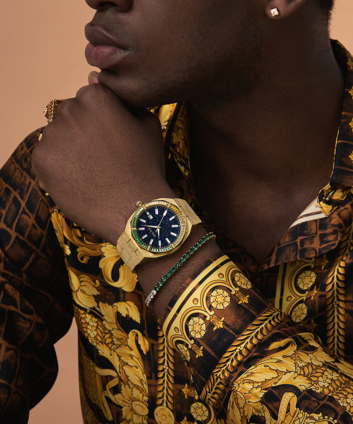 Man wearing a gold Paul Rich watch with blue aventurine dial and green-to-white gem bezel, paired with matching tennis bracelet. Man wearing a gold Paul Rich watch with blue aventurine dial and green-to-white gem bezel, paired with matching tennis bracelet.