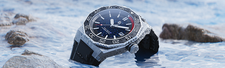 Paul Rich Aquacarbon Pro watch with aventurine dial, black bezel, and rubber strap, resting in shallow water with scattered rocks. Paul Rich Aquacarbon Pro watch with aventurine dial, black bezel, and rubber strap, resting in shallow water with scattered rocks.