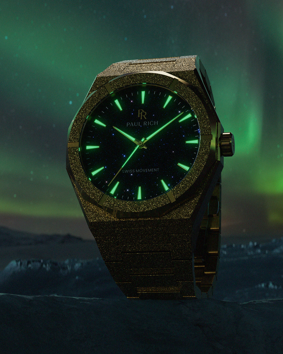 Gold frosted Paul Rich watch with blue aventurine dial and green glowing markers, set against aurora-lit sky and icy mountain landscape. Gold frosted Paul Rich watch with blue aventurine dial and green glowing markers, set against aurora-lit sky and icy mountain landscape.