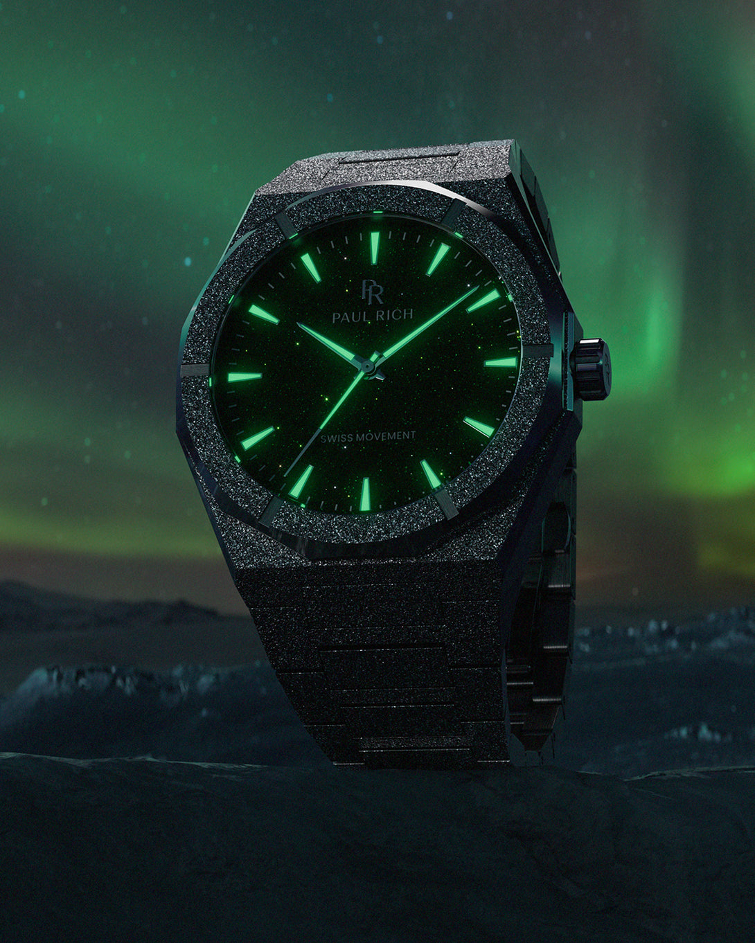 Black frosted Paul Rich watch with glowing green hands and markers, set against a dark arctic landscape and vivid aurora sky. Black frosted Paul Rich watch with glowing green hands and markers, set against a dark arctic landscape and vivid aurora sky.