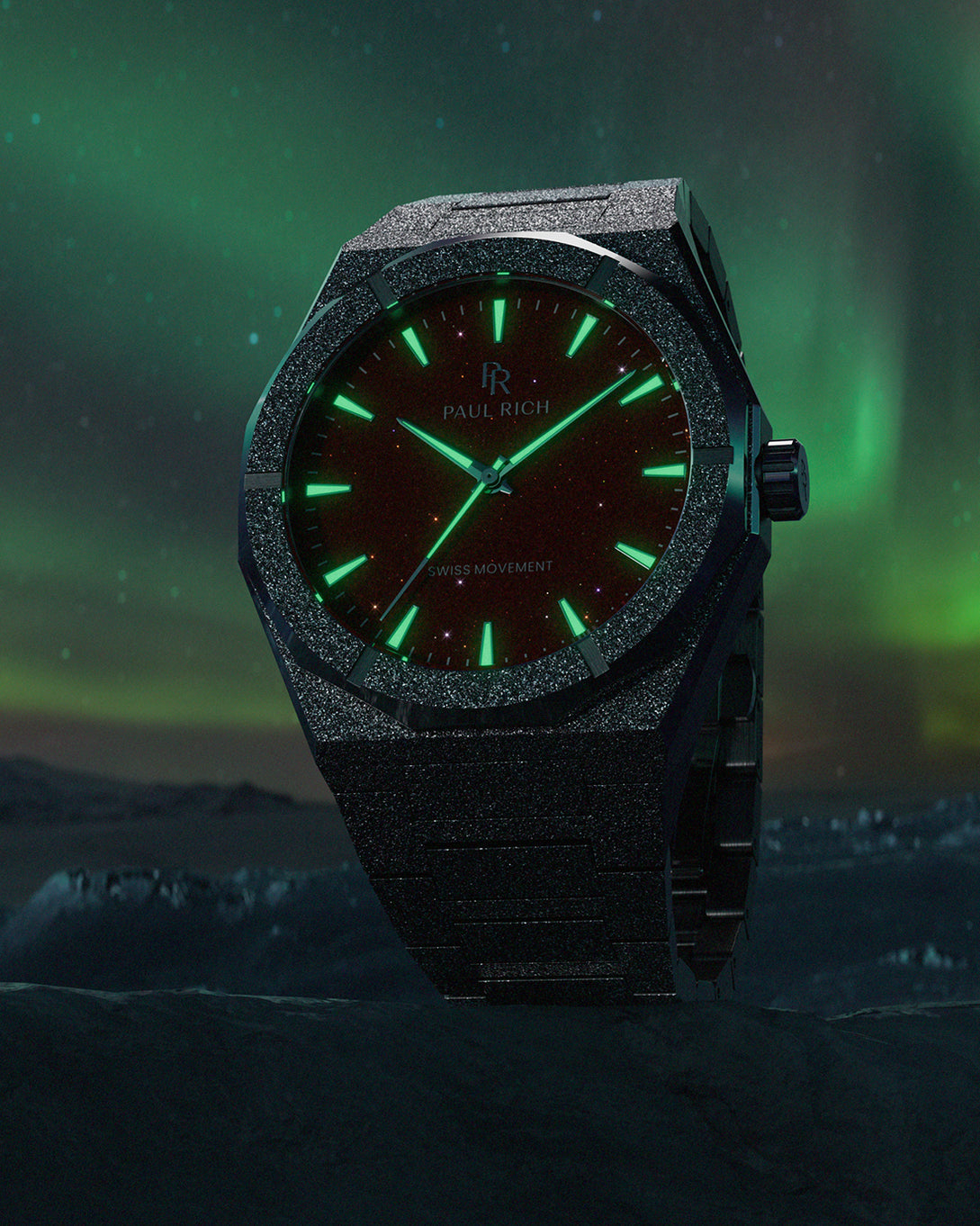 Paul Rich watch with frosted black case and glowing green markers over a red aventurine dial, set against an aurora-lit icy landscape. Paul Rich watch with frosted black case and glowing green markers over a red aventurine dial, set against an aurora-lit icy landscape.