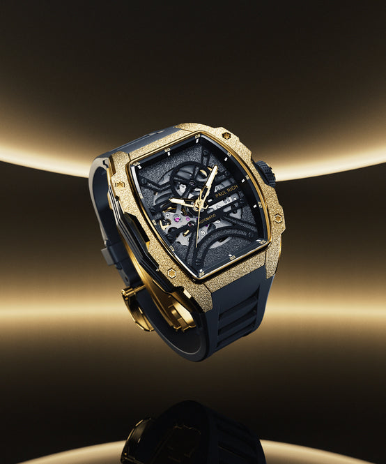Gold Paul Rich tonneau skeleton watch with black strap, shown on dark background with glowing gradient and mirrored reflection. Gold Paul Rich tonneau skeleton watch with black strap, shown on dark background with glowing gradient and mirrored reflection.