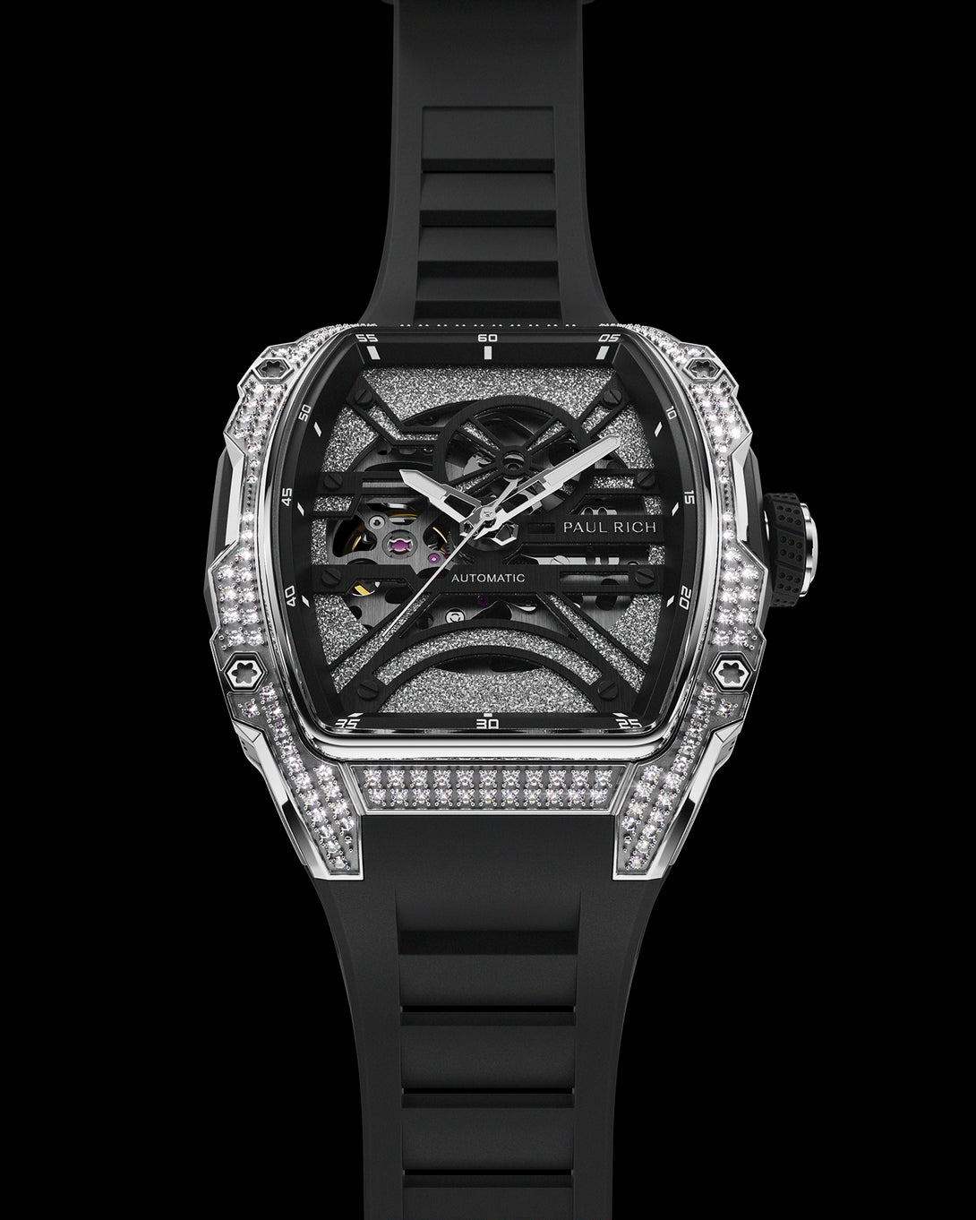 Black tonneau-shaped wristwatch with an open skeleton dial, crystal-set bezel, textured metallic baseplate, and black rubber strap shown vertically. Black tonneau-shaped wristwatch with an open skeleton dial, crystal-set bezel, textured metallic baseplate, and black rubber strap shown vertically.