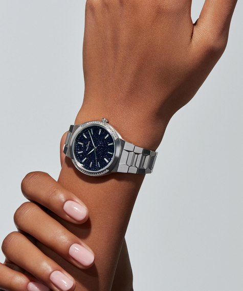 Cosmic Dust Silver aul Rich Cosmic Dust watch in brushed silver case, worn on female wrist with minimalist aventurine dial.