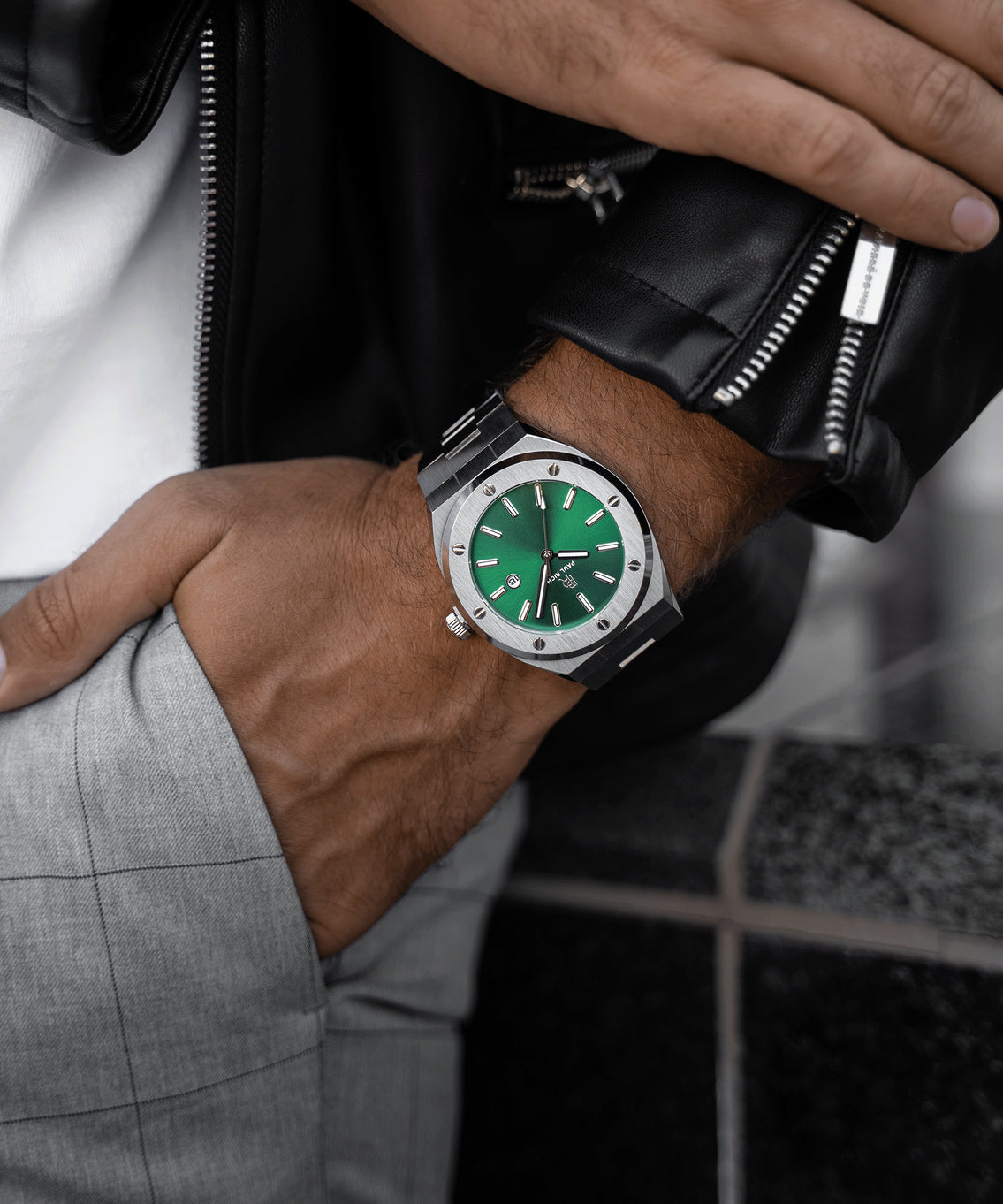 Paul Rich brushed silver watch with green dial and date window, worn with black leather jacket and gray plaid pants, hand in pocket. Paul Rich brushed silver watch with green dial and date window, worn with black leather jacket and gray plaid pants, hand in pocket.