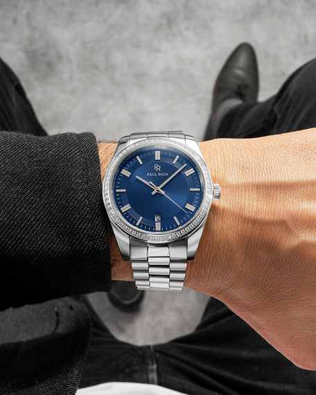 Paul Rich Legacy watch with silver case and blue sunburst dial, shown on wrist.