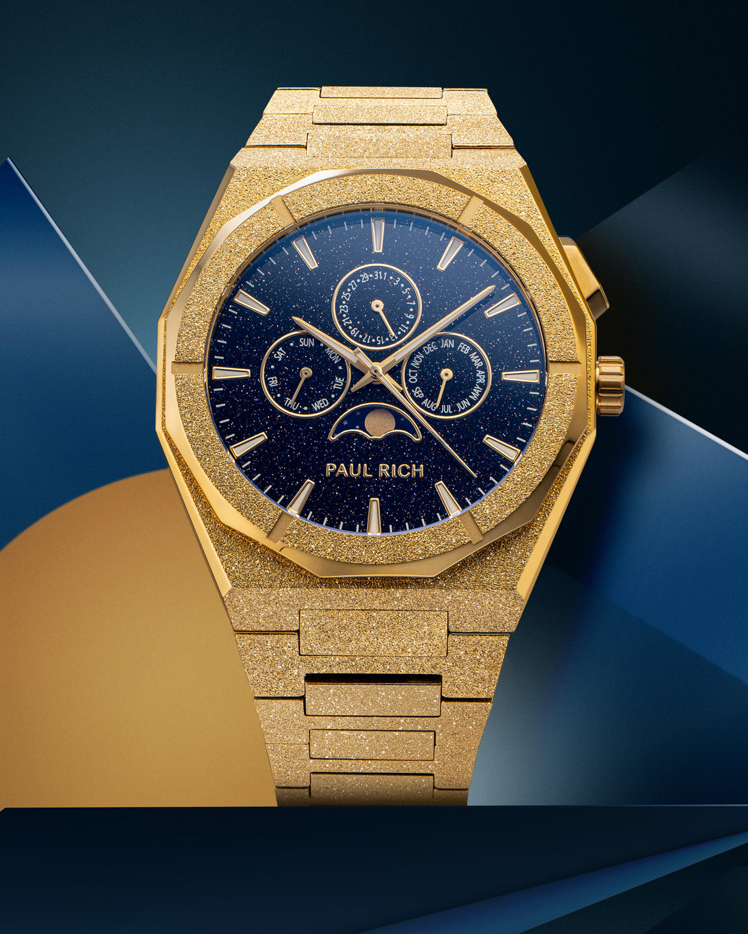 Frosted gold-tone stainless steel watch with blue aventurine dial, moonphase, and subdials, displayed on a geometric blue and gold backdrop.