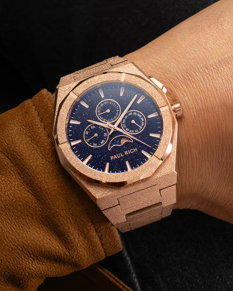 Frosted rose gold moonphase watch on wrist with aventurine dial, calendar subdials, and shimmering textured rose gold bracelet.