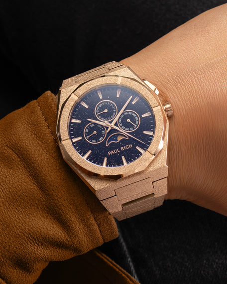 Frosted rose gold moonphase watch on wrist with aventurine dial, calendar subdials, and shimmering textured rose gold bracelet.