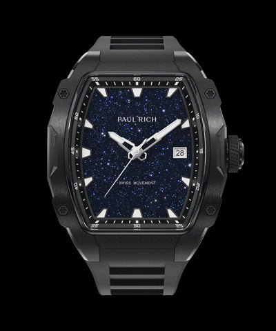 Front view of a black Paul Rich watch with a tonneau-shaped case, blueaventurine dial resembling a starry sky, white hands and markers, date display at 3 o'clock, and labeled “Swiss Movement.”