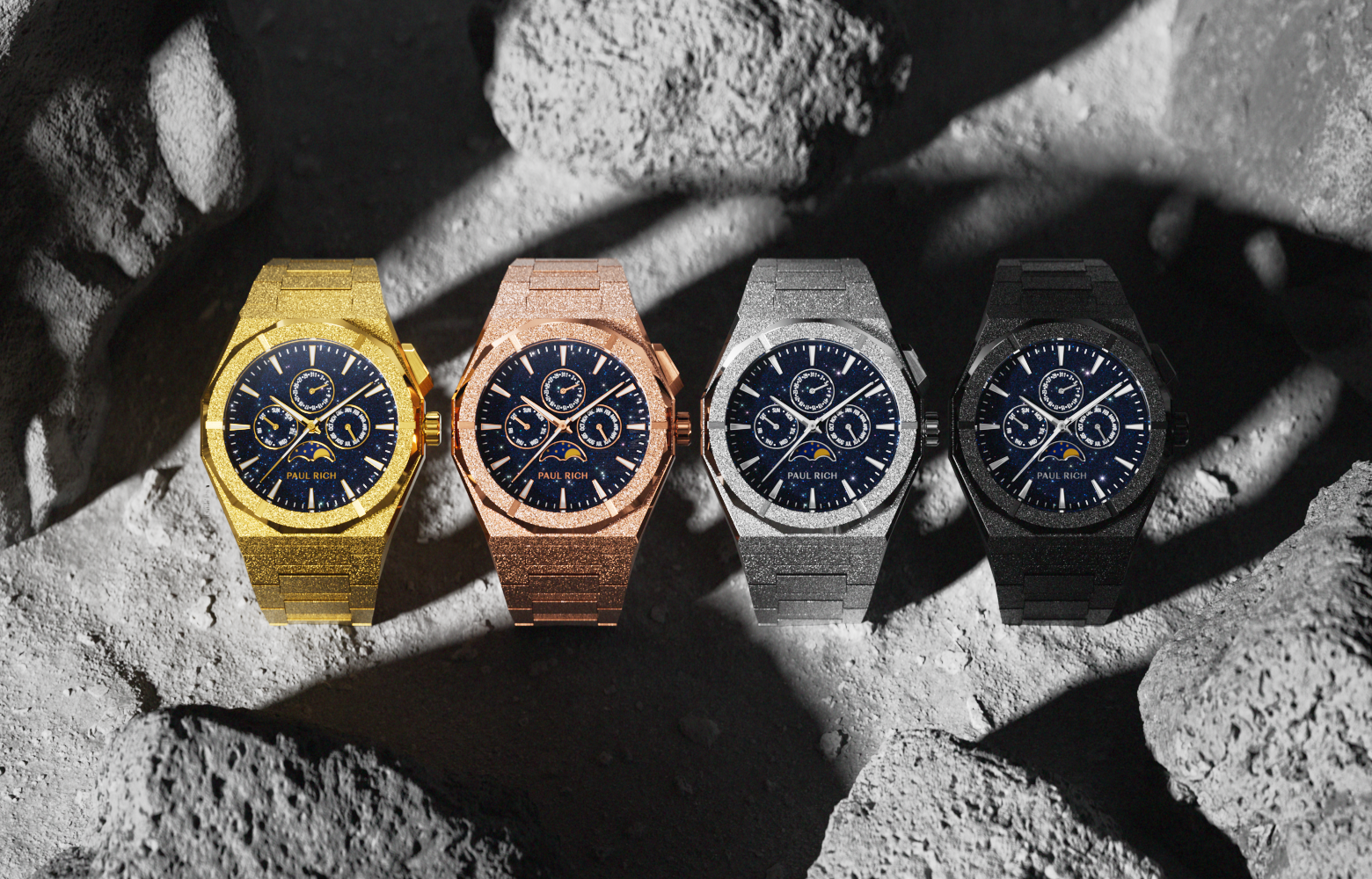 Four Paul Rich Frosted Star Dust II Moonphase watches in gold, rose gold, silver, and black, displayed on a rocky lunar surface background.