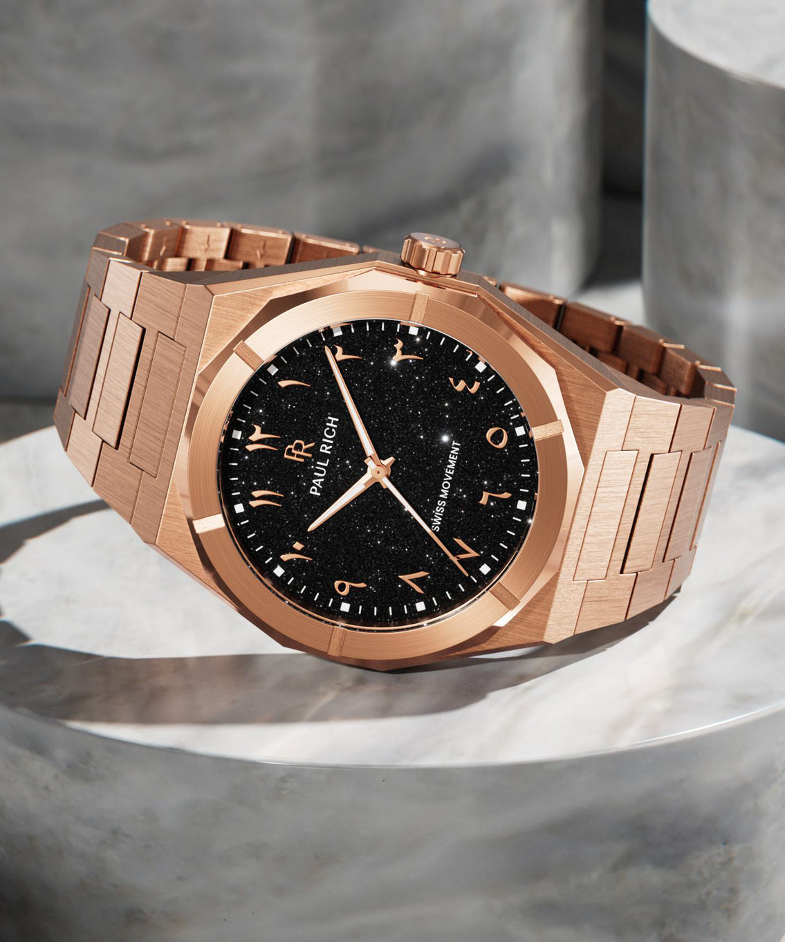 Paul Rich rose gold watch with black aventurine dial and Arabic numerals, displayed on polished stone, featuring Swiss movement.