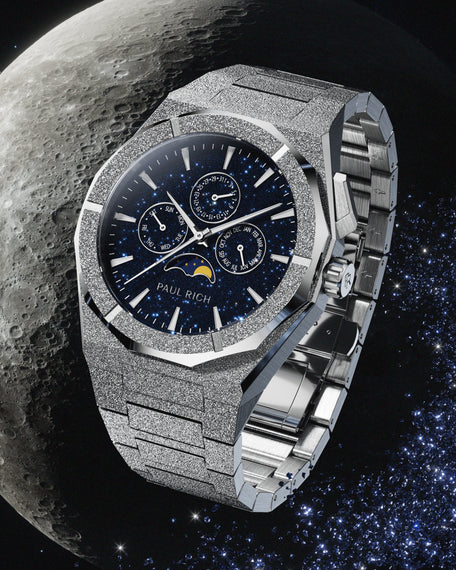 Frosted silver stainless steel watch with blue aventurine dial, moonphase, and subdials, set against a detailed lunar surface and starry space backdrop.    Ask ChatGPT
