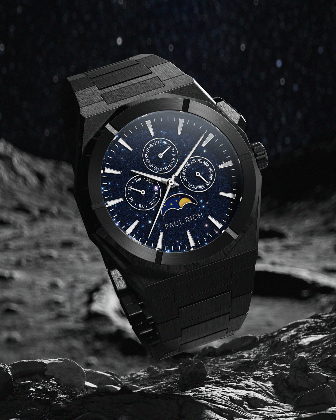 Brushed black stainless steel watch with blue aventurine dial, moonphase, and subdials, set against a rocky lunar surface and star-filled sky.